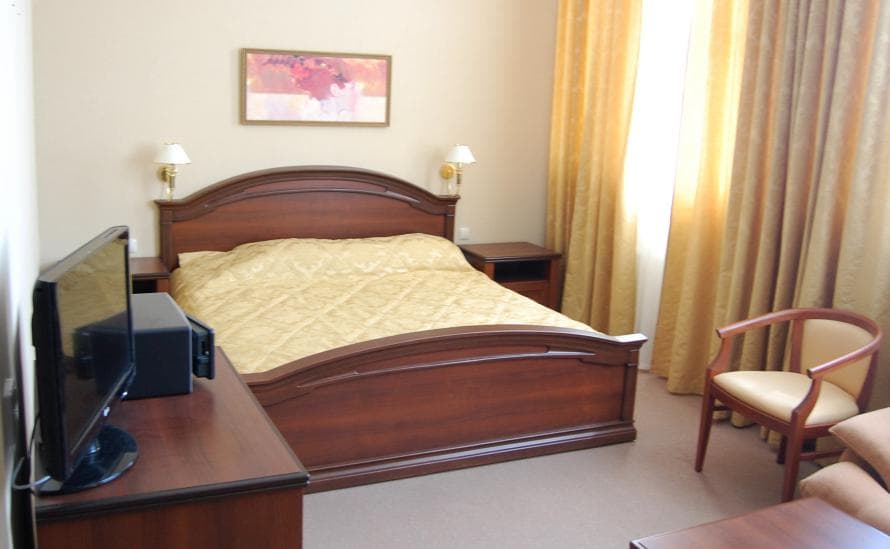Двуспальная кровать в номере отеля HELIOPARK Residence